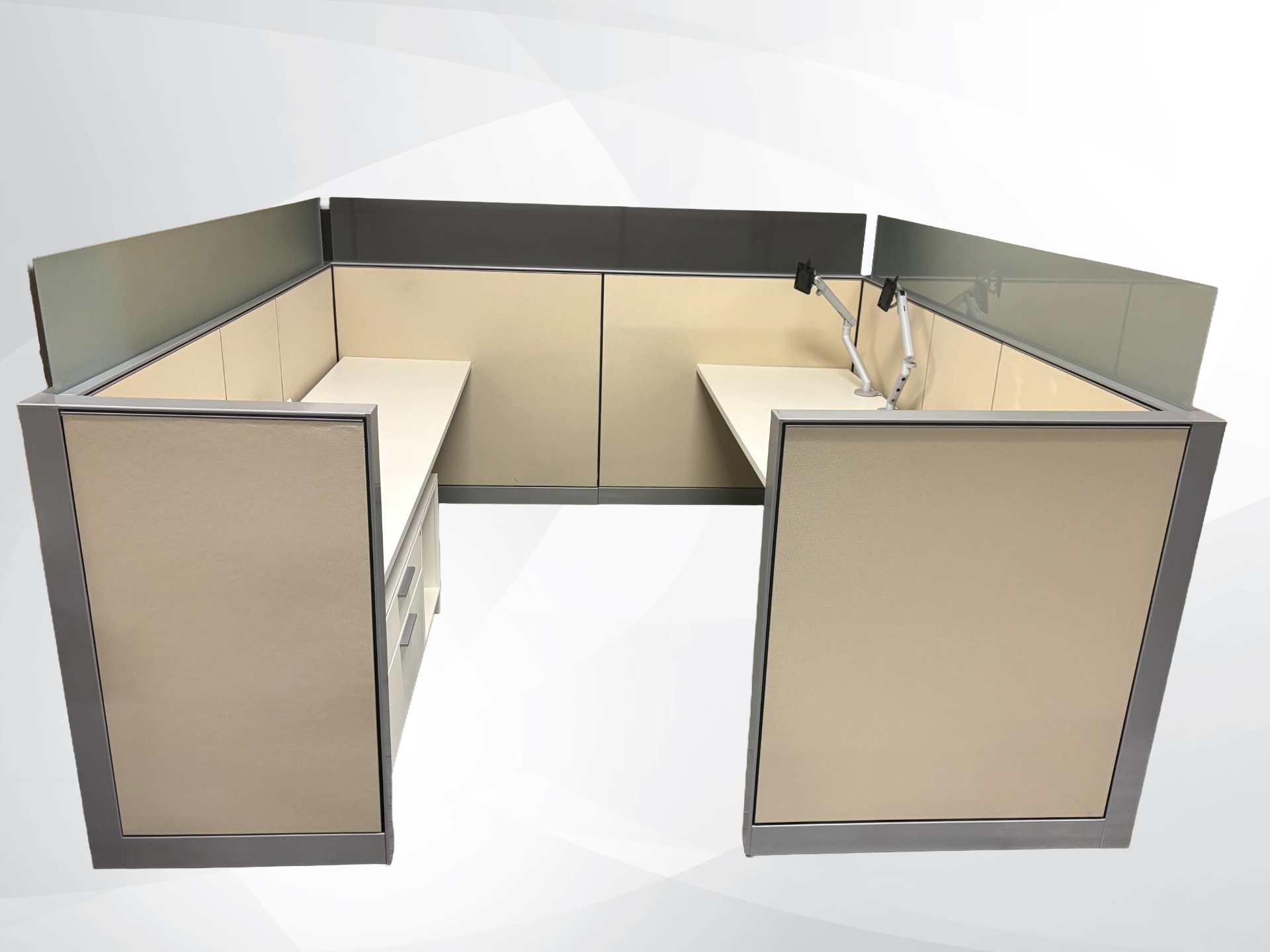 An L-shaped office cubicle desk setup with beige fabric panels, gray metal frames, and a built-in computer monitor stand, shown on a light gray background.