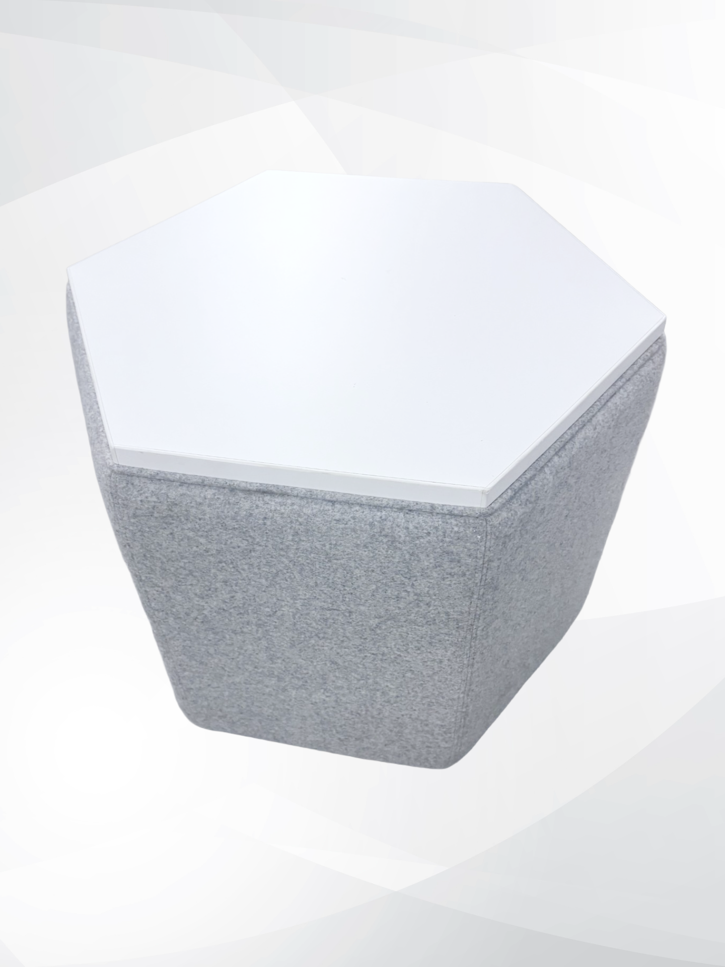 A modern hexagonal pouf or ottoman with a textured gray fabric-covered body and a smooth white top surface, shown on a light gray background.