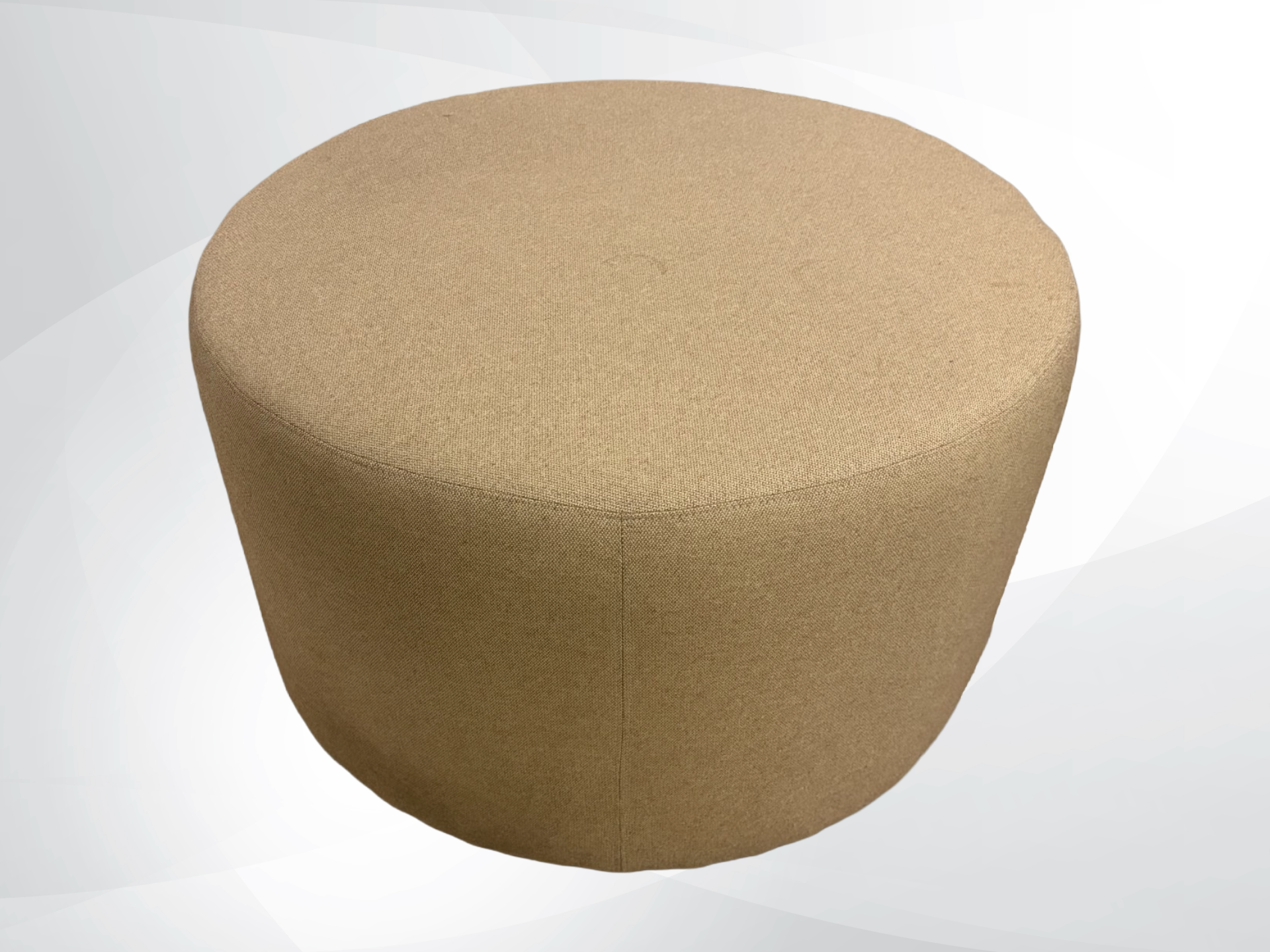 A round upholstered ottoman stool with a textured fabric cover in a warm tan or light brown color, shown against a light gray and white abstract background.