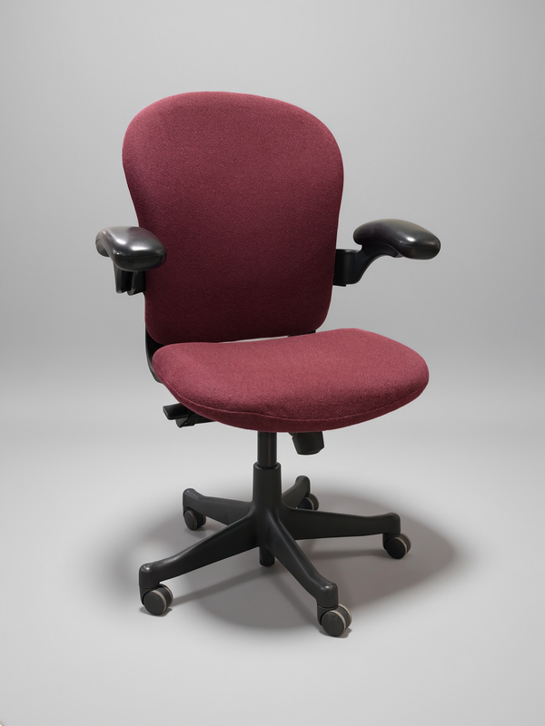A burgundy upholstered office chair with black armrests and a black five-star wheeled base, photographed on a neutral gray studio background.