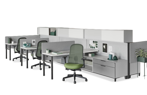 An L-shaped office cubicle desk setup with beige fabric panels, gray metal frames, and a built-in computer monitor stand, shown on a light gray background.