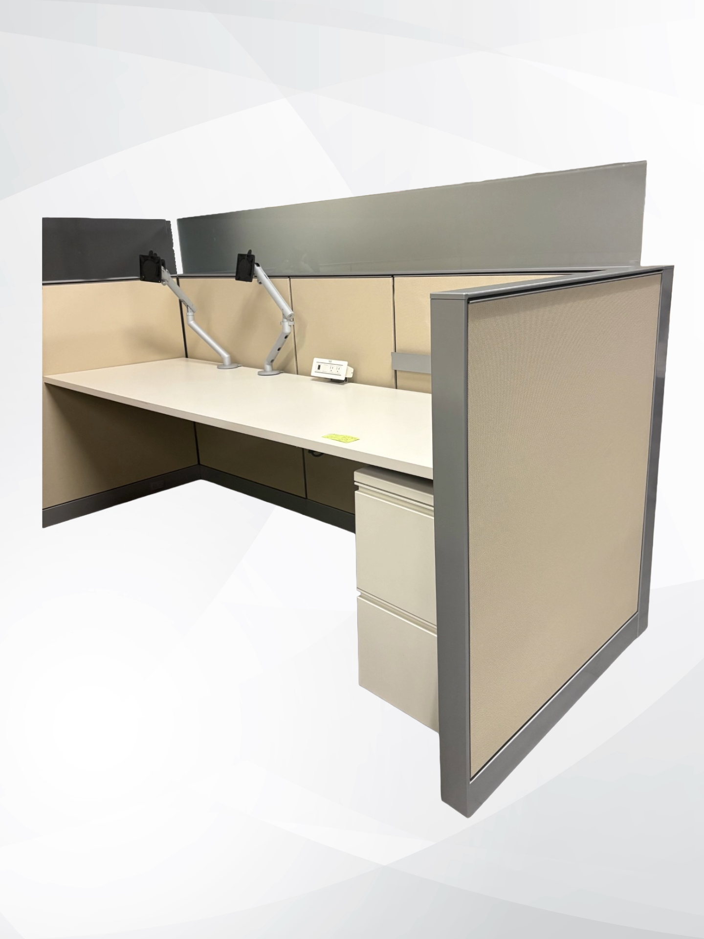 An L-shaped office cubicle desk set with beige fabric dividers, gray metal framing, a cream desk surface, and a matching two-drawer pedestal file cabinet, shown on a light gray background.