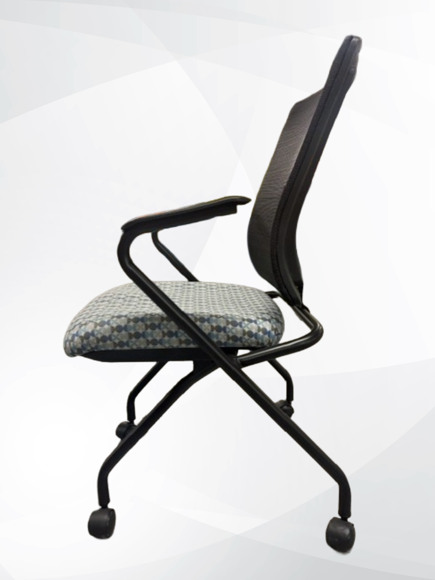A modern office chair with a black mesh backrest, black metal frame, and castor wheels, featuring a patterned gray and blue seat cushion.