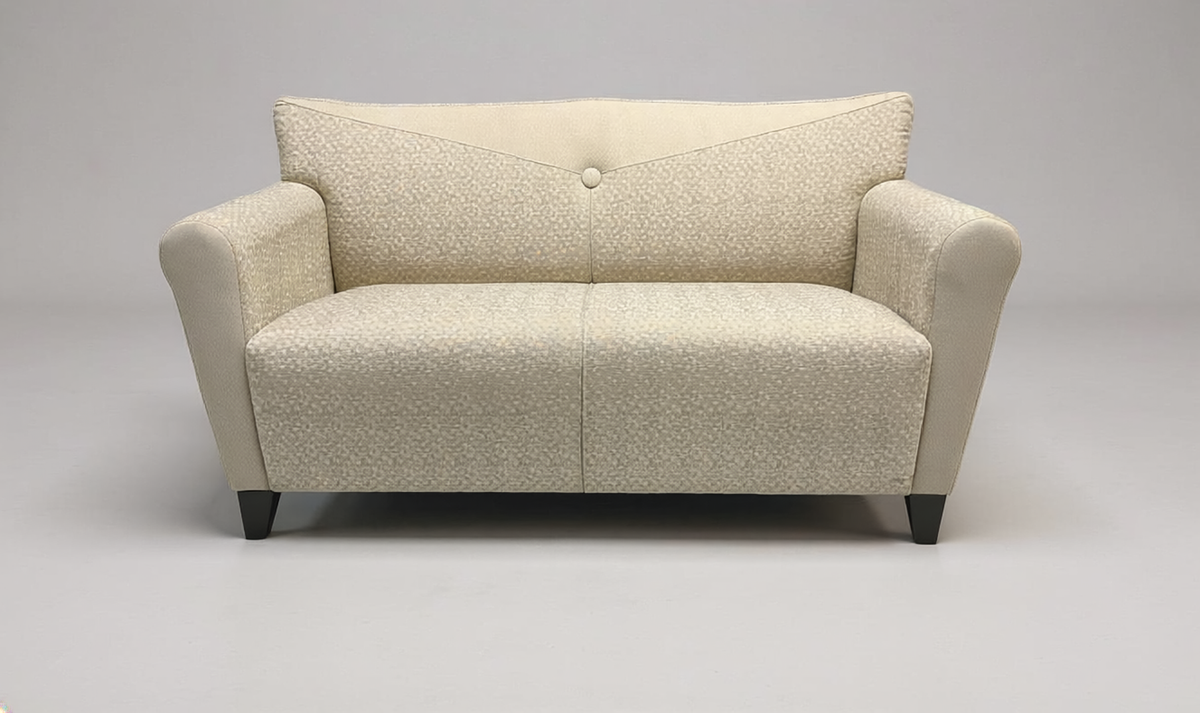 A modern two-seater loveseat sofa upholstered in a textured cream fabric, featuring a curved backrest with a central button tuft, wide armrests, and dark tapered legs, shown on a neutral gray background.