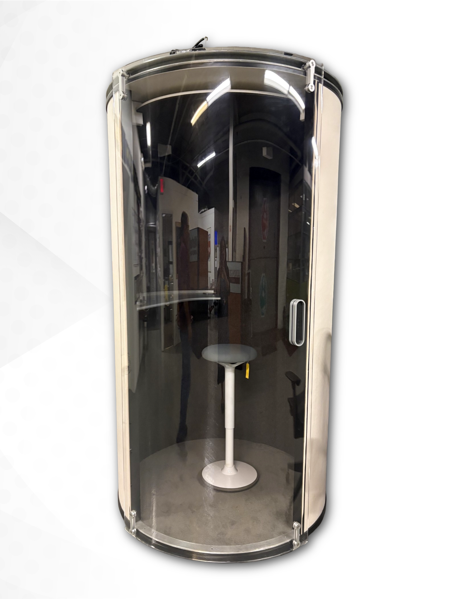 A modern cylindrical glass privacy booth with a metallic silver frame and a small white pedestal table inside, shown against a plain white background.