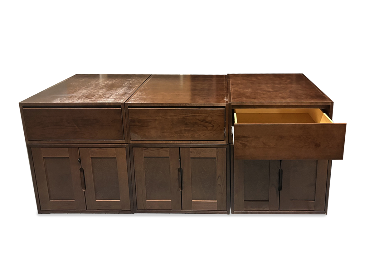 A dark brown wooden storage lockers unit with three drawers and three cabinet doors, with the rightmost drawer pulled open to show a light wood interior, set against a plain white background.