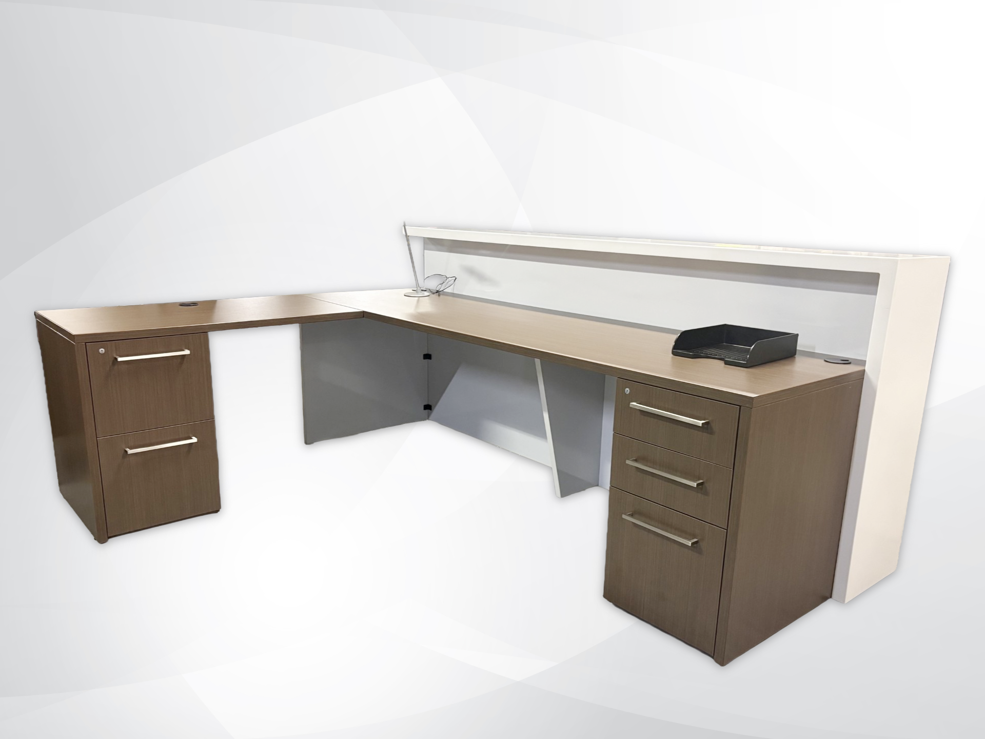 An L-shaped office desk with a wood-grain finish, featuring two separate filing cabinets (one double drawer, one triple drawer) and a clear desk divider, shown on a light gray background.